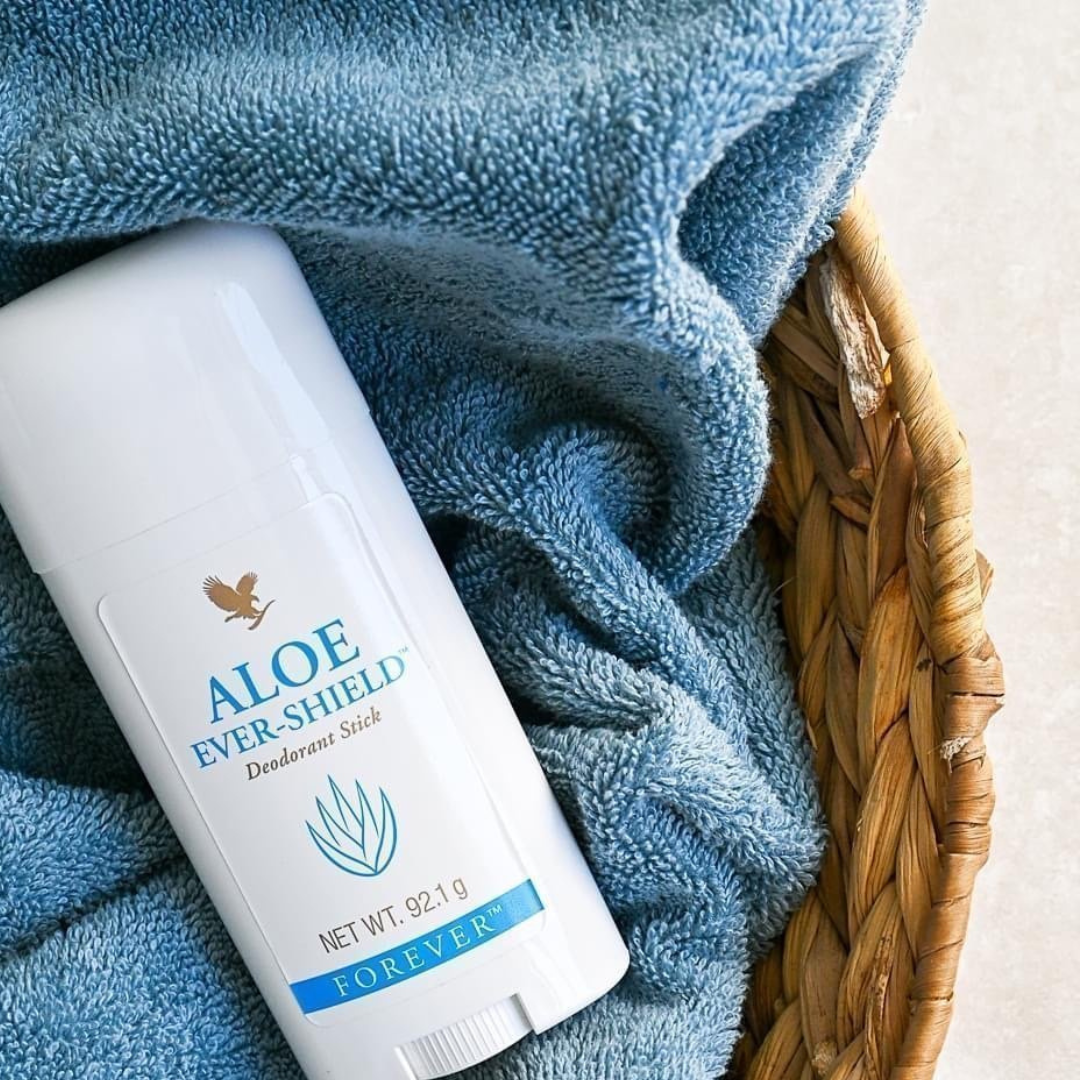 Forever Aloe Ever-Shield deodorant placerad i korg med mjuk blå handduk.